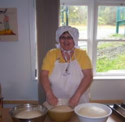 Bread Making Workshop. A member of the French Shore Historical Society poses with rising dough, Conche, Newfoundland
