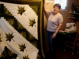 Bussey, Louise. Louise Bussey poses with her patchwork leaf quilt, St. Lunaire-Griquet