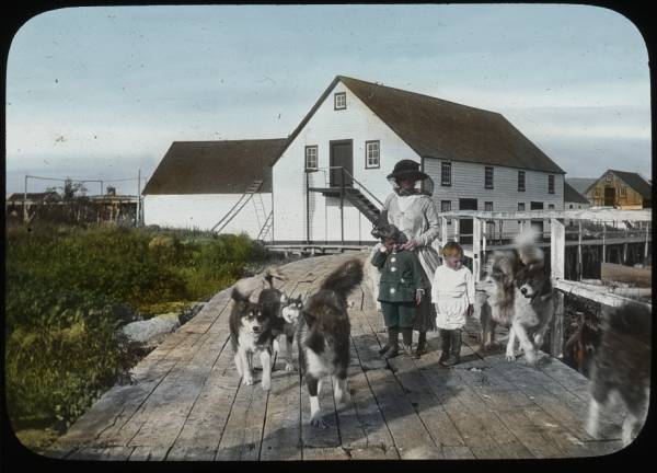 Building, adult, two children, dogs