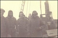 William Hynes, homme non identifié, Steve Tulk et Capitaine Godfred Tulk, à bord d'un navire non identifié.