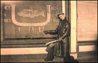 Randolph Tulk pointant l'enseigne du FPU inscrit sur le store du commerce de la  Fishermen's Union Trading Company à Port Union.