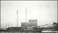 Fishermen's Union Trading Company sealing plant with one of the companys schooners in foreground.