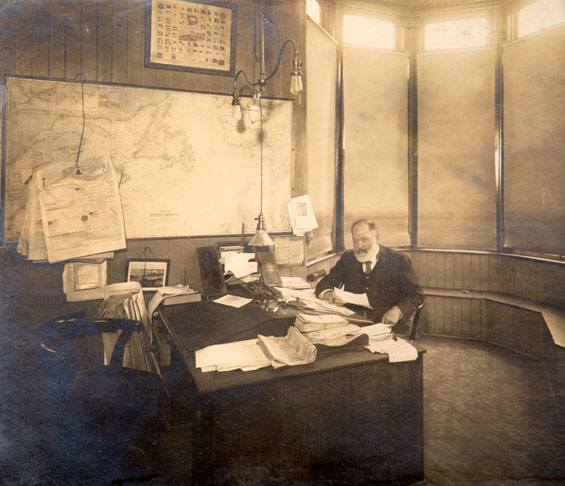 Mr. G.A. Hutchings sitting at his desk