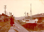 A man observing the vessel "Beothic" on dry dock in the west end of St. John's harbour