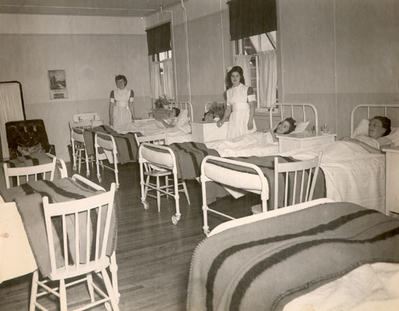 Nurse's aids, Joan March (left) and Aggie Cramm with patients on the women's ward, Bonavista Cottage Hospital