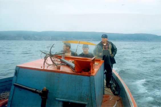 Fishermen in a fishing boat going to catch some cod fish