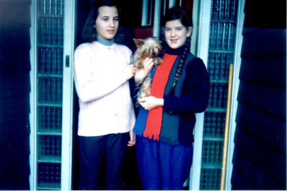 Harold L. Lake's daughter (right) holding her Yorkshire Terrier in front of the Lake home known as 