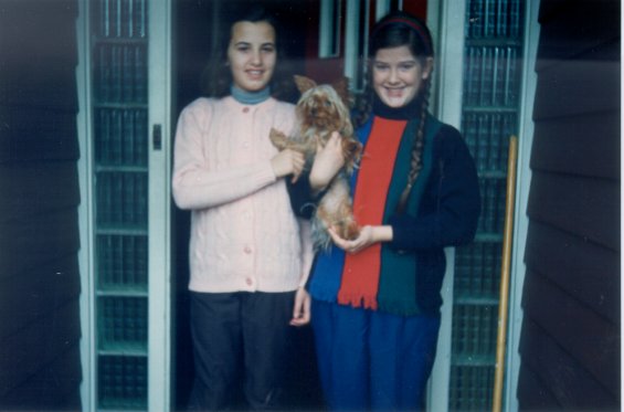 Harold L. Lake's daughter (right) holding her Yorkshire Terrier in front of her home known as 