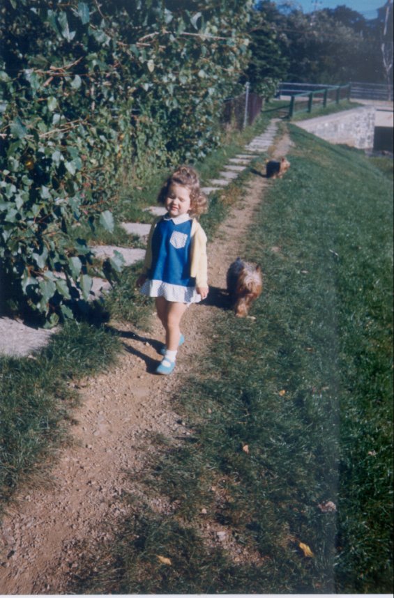 Harold L. Lake's daughter walking on a pathway with her Yorkshire Terriers