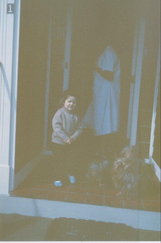 Harold L. Lake's daughter standing in the front doorway of the Lake family home known as 