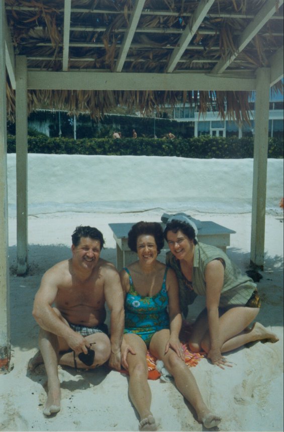 Harold L. Lake, his wife, Robin (centre), and a woman on a sandy beach in St. George, Bermuda during a vacation