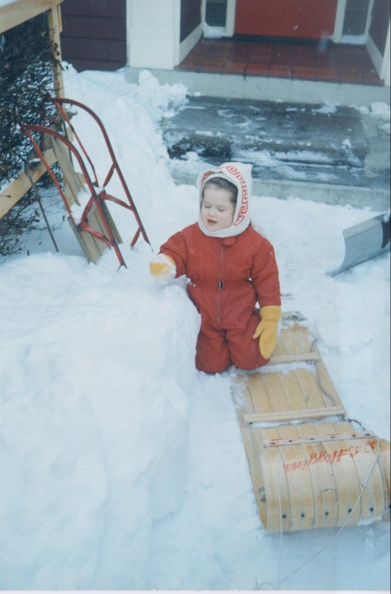 Harold L. Lake's daughter playing in the snow in front of the Lake family home known as 