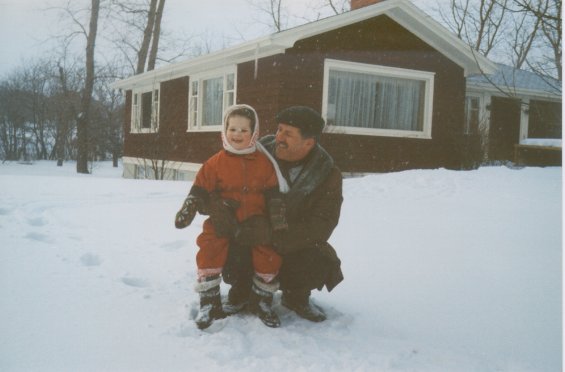 Harold L. Lake with his daughter playing in the snow in front of their home known as 