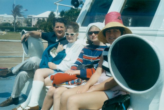 Harold L. Lake and two of his daughters with another girl, sitting on a boat in St. George, Bermuda