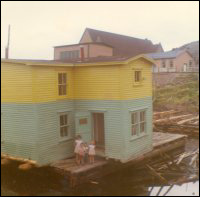 Maison de Jack Wadman sur la barge, prête pour le remorquage de Bar Haven à Southern Harbour (baie de Placentia)