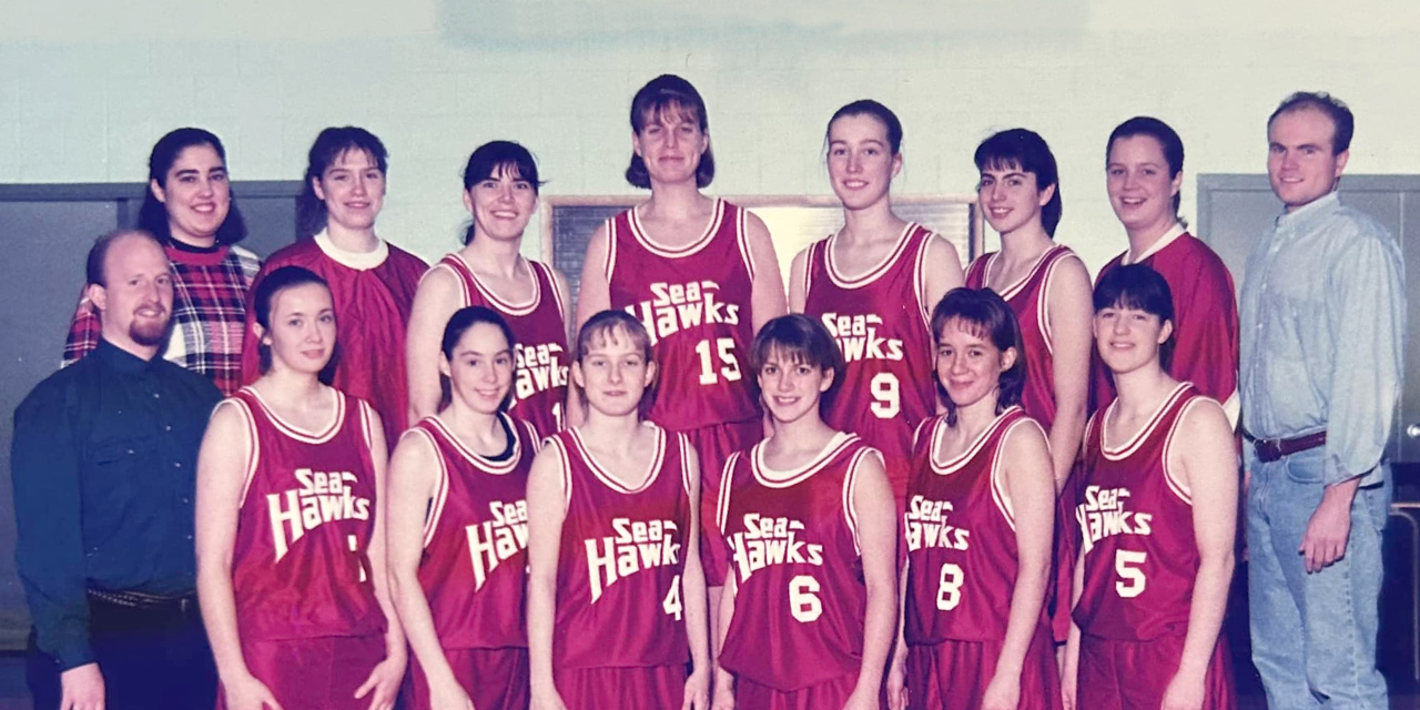 A vintage team photo of a women's varsity basketball team wearing red 
