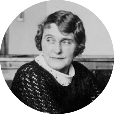 Black and white photograph of Monnie Mansfield seated at her desk