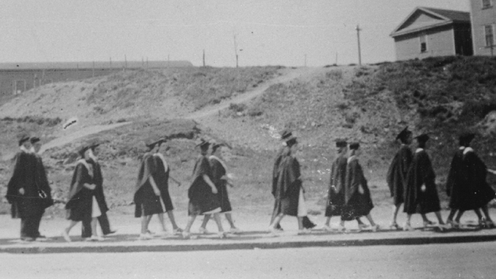 Students in caps and gowns parade through St. John’s on their way to their graduation ceremony