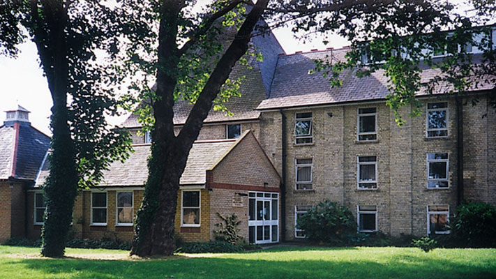 An english cottage style brown brick building with at least 4 stories