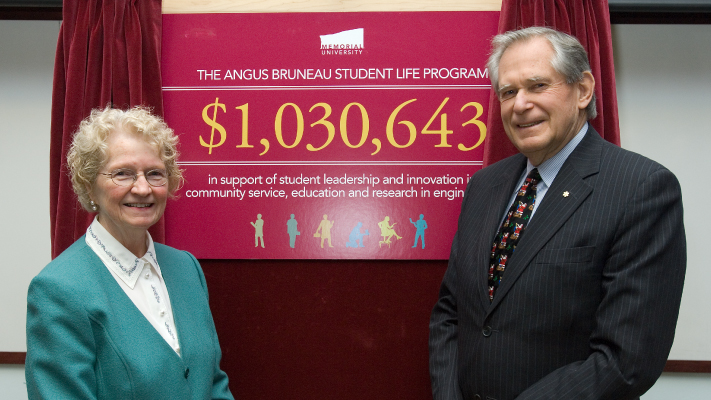 A photo of Drs. Angus and Jean Bruneau presenting a cheque