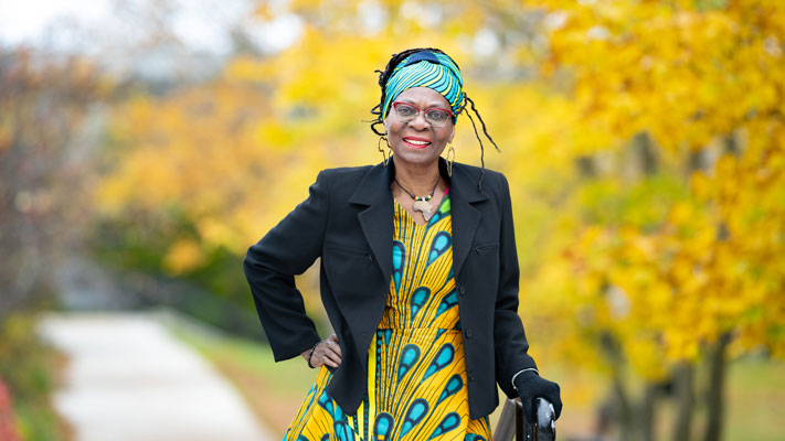 Dr. Delores V. Mullings, Memorial University’s first Vice Provost of Equity, Diversity, Inclusion, and Anti-Racism, stands outdoors smiling in front of autumn trees.