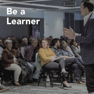 image of man in suit presenting to crowd