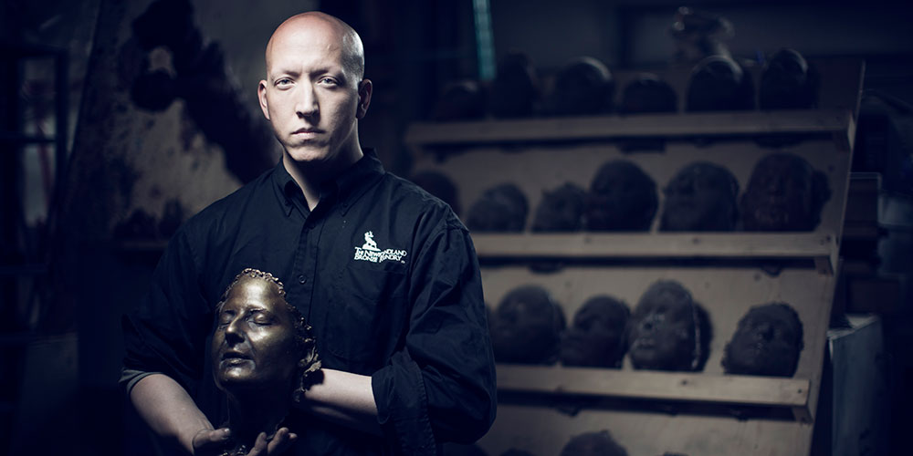 Morgan MacDonald sculptor in front of 100 Potraits of the Great War exhibit