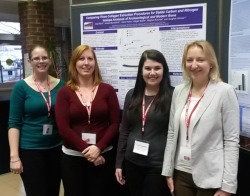 Megan Bower, Asta Rand, Jess Munkittrick, and Alison Harris in front of the poster they collaborated on