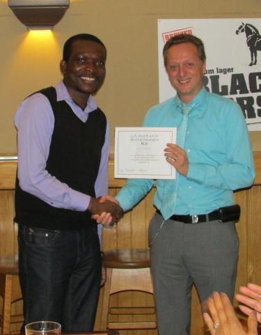 Dr. Mark Berry presents Kayode Balogun with the certificate for L.M Stead Oral Competition Award