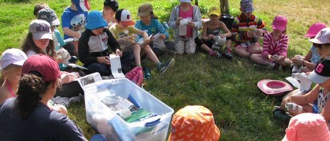 camp kids in a circle making newspaper flower pots