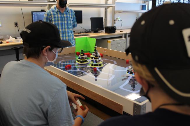 Teens sitting around a table the lego robotics