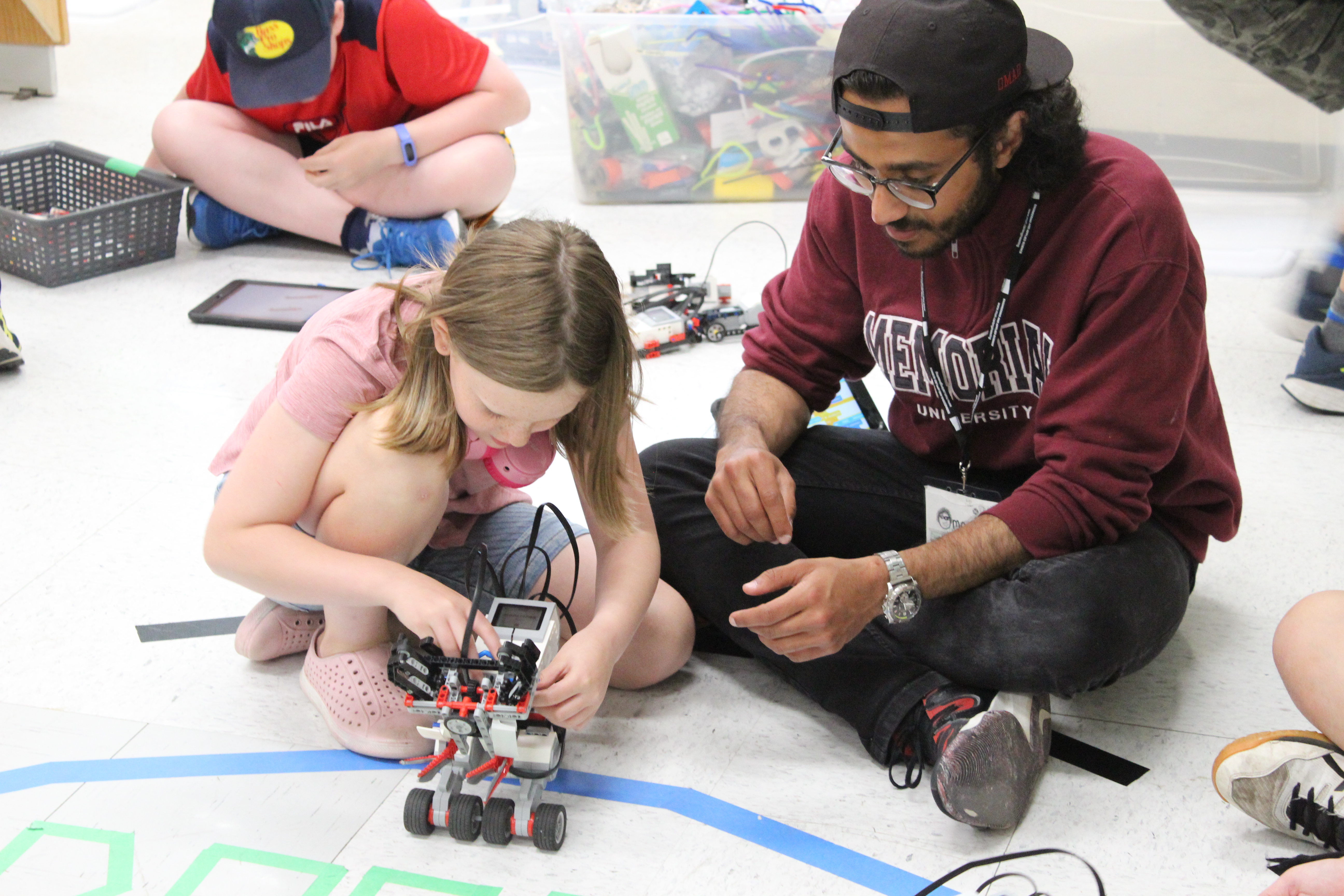 New Lego robot with young girl and program facilitator