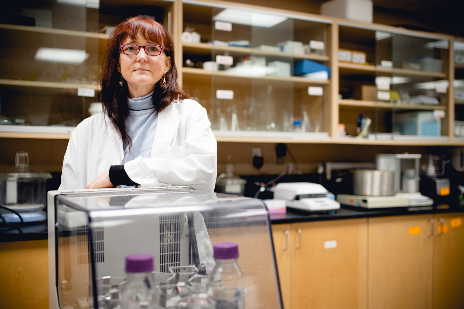 Woman wearing a white lab coat standing in a laboratory.