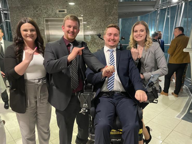 Four individuals proudly display their iron rings.