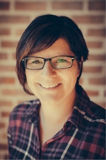 Woman smiling in front of brick wall