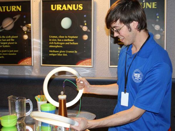 an interpreter conducts a science experiment with electricity