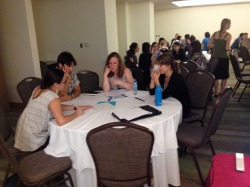 Students gather round table for discussions.