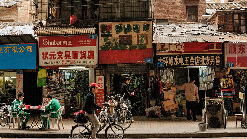 outside a busy street-side market life continues at a hectic pace