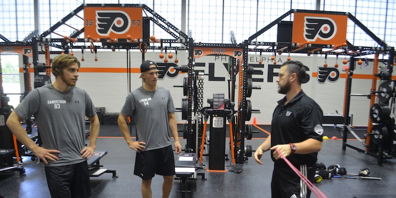 Chris Osmond (right), head strength and conditioning coach with the Philadelphia Flyers, working with prospects at a training camp in summer 2017.