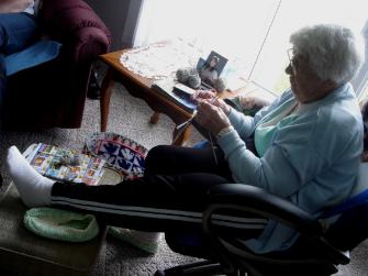 Chambers, Laura. Laura Chambers sitting and knitting in her chair, Flower's Cove