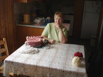 Rice, Betty. Betty Rice poses for a photo at her kitchen table, Main Brook