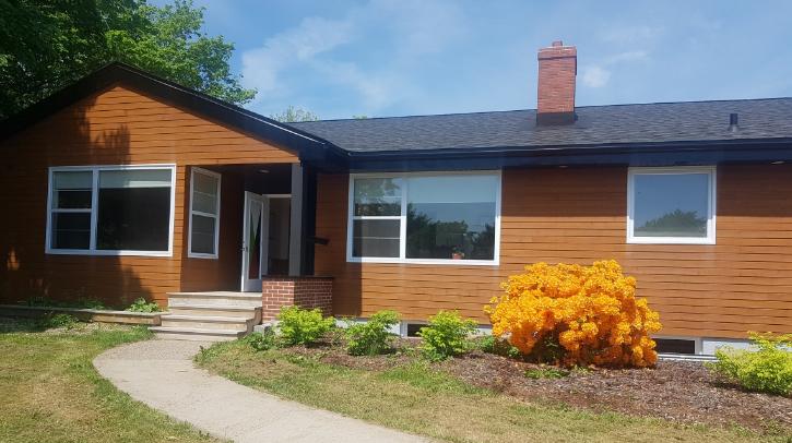 Juniper House, exterior of a brown house with orange bush outfront