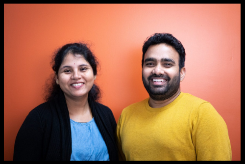 Nucliq Biologics Founders Dr. Nikitha Kendyalan and Dr. Purvikalyan Pallegar stand in front of an orange background while smiling at the camera.