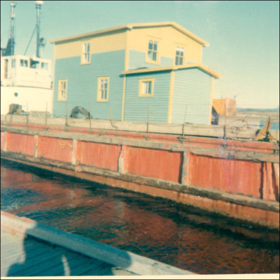 Maison de Charles Holly amarrée à Garnish sur la barge de l'État, après avoir été remorquée de Point Rosie (baie de Fortune)