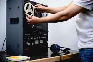 Loading a reel onto the reel-to-reel playing in the archive's studio