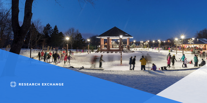 Photo of Bannerman Park. There are people ice skating around a gazebo. It is dusk.