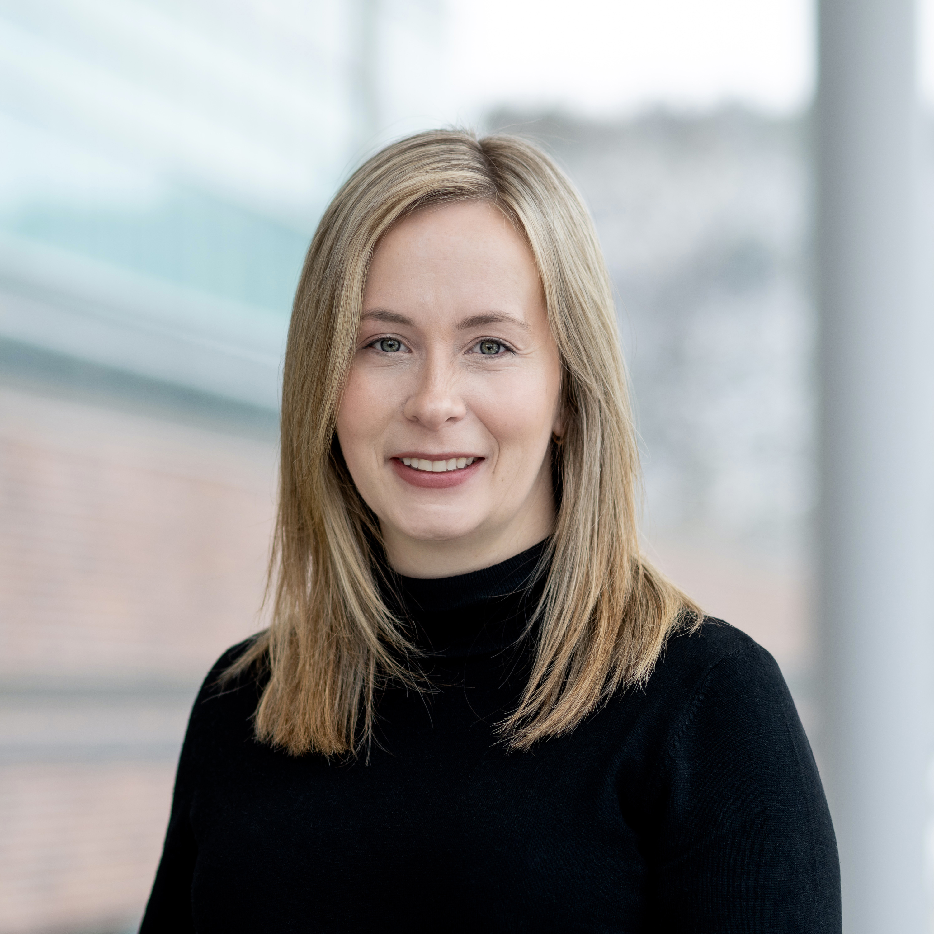 Photo of Dr. Cathy Balsom, a young mom, pharmacist and instructor at the School of Pharmacy. Photo taken in the glass atrium of the Med School at MUN.