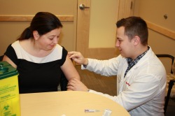 Dr. Carla Dillon (left), associate dean of undergraduate studies, receives her flu vaccination from pharmacist and School of Pharmacy alumnus Michael Butler (Class of 2011).