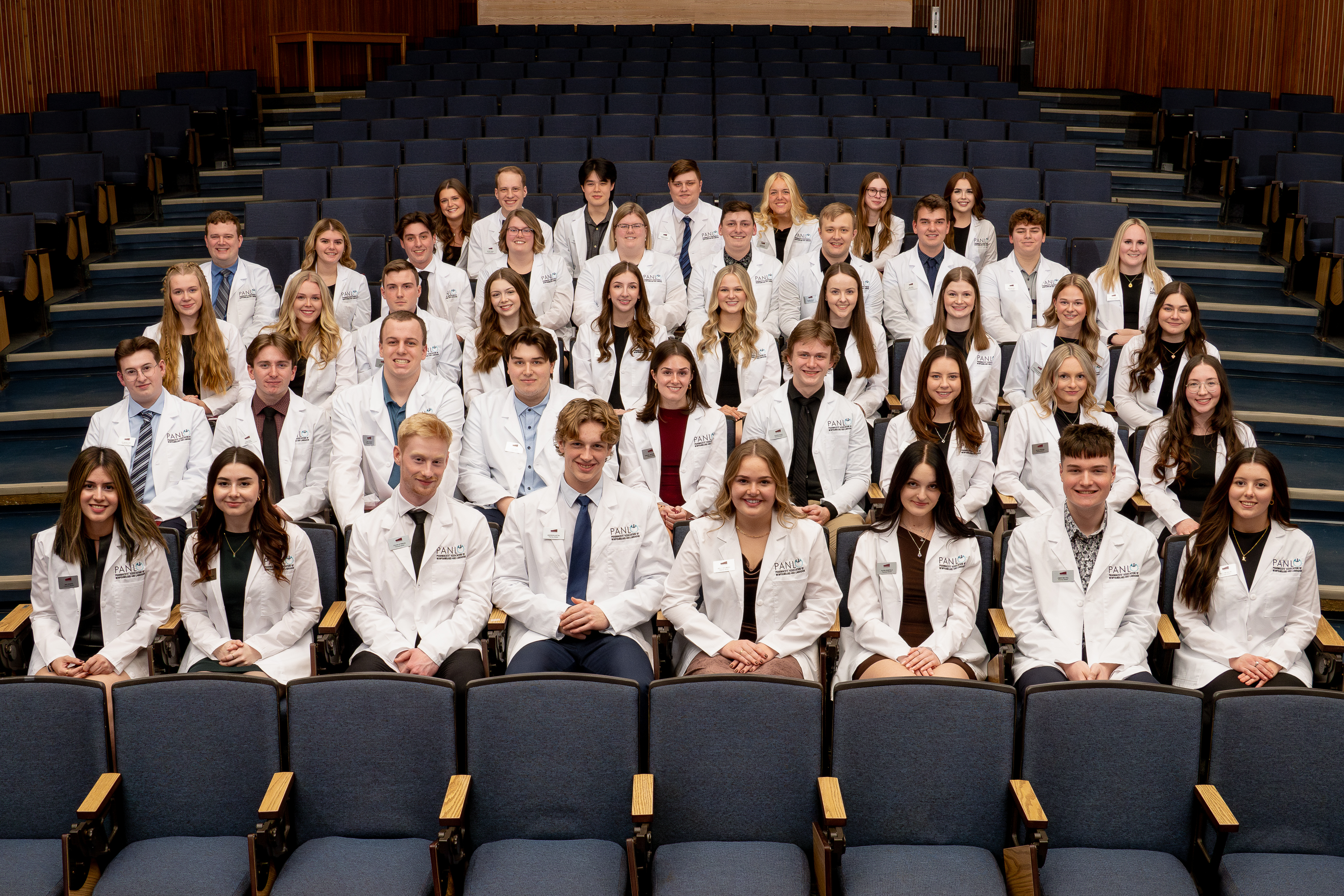 White Coat Ceremony 2025 - Class of 2029 - A photo in the main auditorium at the HSC of the Class of 2029 donning their new white coats for being inducted into the pharmacy profession.