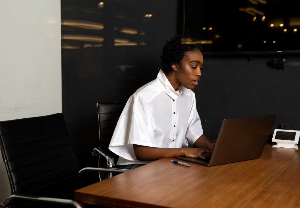 A non-binary person using a laptop